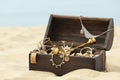 Open wooden treasure chest on sandy beach Royalty Free Stock Photo