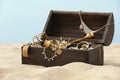 Open wooden treasure chest on sandy beach Royalty Free Stock Photo