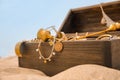 Open wooden treasure chest on sandy beach, closeup Royalty Free Stock Photo