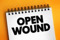 Open Wound - injuries that involve a break in the skin and leave the internal tissue exposed, text concept on notepad
