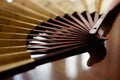 Open yellow fan with brown chinese characters on the table, closeup, side view Royalty Free Stock Photo