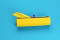 An open yellow pencil case with protruding pencils on a blue background. Flat lay Royalty Free Stock Photo