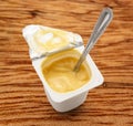 Open yogurt in pot with metal spoon