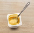 Open yogurt in pot with metal spoon