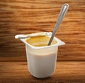 Open yogurt in pot with metal spoon