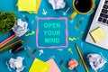 Open your mind. Office table desk with supplies, white blank note pad, cup, pen, pc, crumpled paper, flower on blue