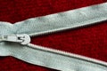 Open zipper with a runner on a red cloth Royalty Free Stock Photo