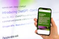 Openai chat gpt on mobile phone and computer in background Royalty Free Stock Photo