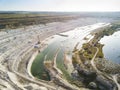 Opencast mining quarry with machinery at work - Aerial view. Industrial Extraction of lime, chalk, calx, caol. View from above