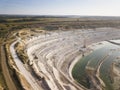 Opencast mining quarry with machinery at work - Aerial view. Industrial Extraction of lime, chalk, calx, caol. View from above