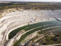 Opencast mining quarry with machinery at work - Aerial view. Industrial Extraction of lime, chalk, calx, caol. View from above