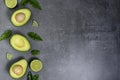 Opened avocado showing seed on textured stone background