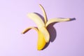 Opened banana on violet background Fresh fruit