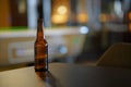 Opened beer bottle on a wooden table. Copy space, mock up.