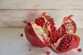 Opened big red pomegranate with seeds on the white concrete surface. Sliced juice pomegranate on the light background