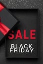 Opened black gift box with red ribbon on dark granite surface. Black friday sale. Empty box