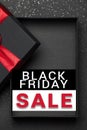 Opened black gift box with red ribbon on dark granite surface. Black friday sale. Empty box