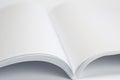 Opened blank magazine with white pages on white background and close-up selective view Royalty Free Stock Photo