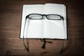 Opened blank notebook with eyeglass on wooden Royalty Free Stock Photo