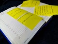 Opened book calendar and planner with hours and lines of a day full of yellow sticky notes with writings on it