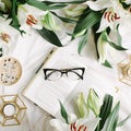 Opened book, coffee cup, candlestick, glasses and fresh flowers on the white bed. Flat lay, top view Royalty Free Stock Photo