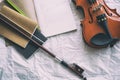 The opened book with drawing note put at the middle of half front side of violin and bow Royalty Free Stock Photo