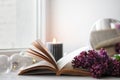 Opened book with flowers. Cozy spring atmosphere at home. Blooming lilac