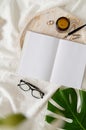 Opened book, glasses, candle and flowers top view on white bed. Mock up design Royalty Free Stock Photo