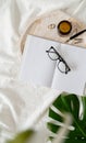 Opened book, glasses, candle and flowers top view on white bed. Mock up design Royalty Free Stock Photo