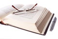 Opened book with glasses and pen Royalty Free Stock Photo