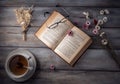 Opened book, glasses, pink flowers, cup of tea on wooden background. Royalty Free Stock Photo