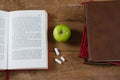 Opened book, green apple and chalk on wooden table Royalty Free Stock Photo