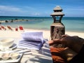 Opened book and legs on a bench with a sea view background