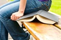 Opened book next to a woman sitting on a bench Royalty Free Stock Photo