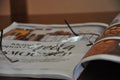 Opened book and reading glasses lying on brown table. Glasses on an open book. Shallow depth of field.