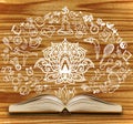 Opened book with yoga sketches on a wooden background Royalty Free Stock Photo