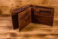 Opened brown leather wallet on wooden table