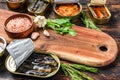 Opened cans conserve with saury, salmon, sprats, sardines, squid and tuna. Dark Wooden background. Top view. Copy space Royalty Free Stock Photo