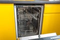 Opened dishwasher in the yellow kitchen Royalty Free Stock Photo