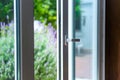 Opened door of a family home. Lock of the sliding door with the yard of background. Royalty Free Stock Photo