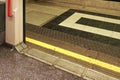 Opened doors of London underground tube train with yellow line on ground