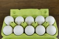 Opened egg box with ten eggs inside  on a wooden background. Fresh organic chicken eggs in carton or egg container. Royalty Free Stock Photo