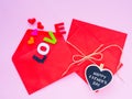 Opened envelope and many felt hearts. colorful of hearts with LOVE text on pink background.