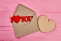 Opened envelope and wooden heart.