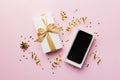Opened gift box with gold ribbon and smartphone on color background, top view. Blank open box packaging mockup Royalty Free Stock Photo