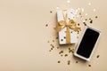 Opened gift box with gold ribbon and smartphone on color background, top view. Blank open box packaging mockup Royalty Free Stock Photo