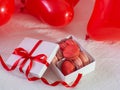 Box with macaron cookies and red baloons on the bed Royalty Free Stock Photo