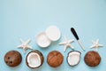 Opened glass jar with fresh coconut oil and ripe coconuts on blue background. Homemade coconut products Royalty Free Stock Photo