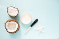 Opened glass jar with fresh coconut oil and ripe coconuts on blue background. Organic healthy food concept. Beauty and SPA concept Royalty Free Stock Photo