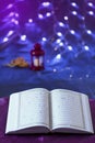 Opened HOLY Quran on silky fabric bokeh background